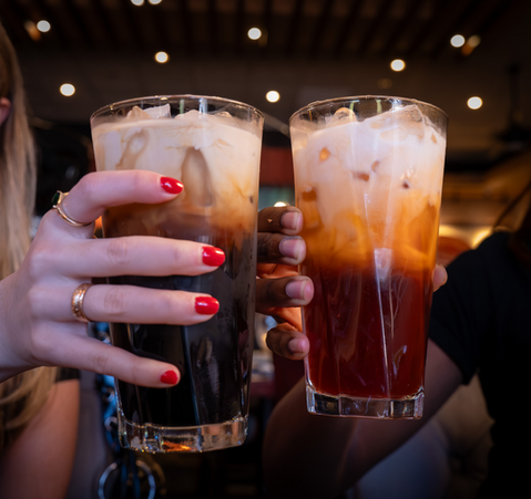 Hands holding two glasses of iced coffee, Aiyara Thai Cuisine.