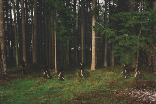 Multiple exposure of model in black faded and running in woods