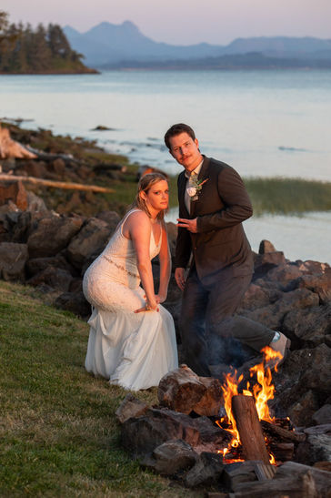 Bride and groom being goofy by campfire