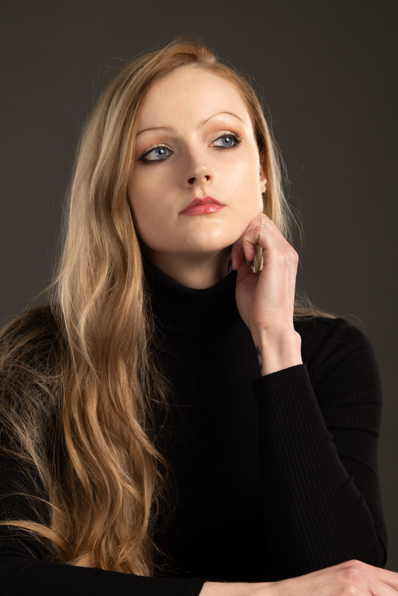 Beautiful woman in black in studio for professional corporate headshots