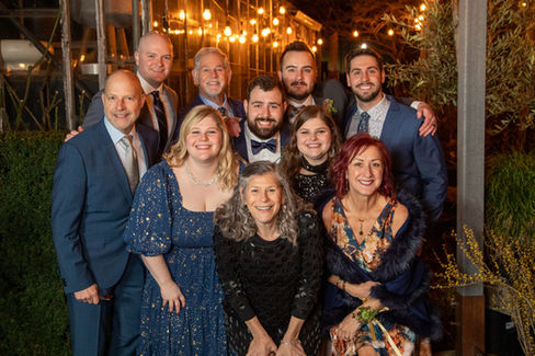 Warm light on excited wedding party in a dark nursery setting