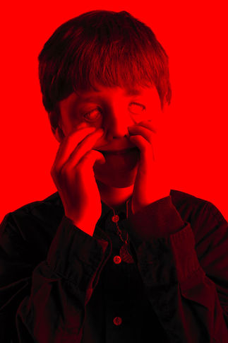 Child in photo studio dark red and eerie