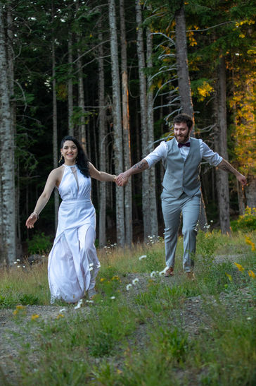 Bride and groom run hand in hand in warm sunset glow at their Mount Hood, Oregon, wedding