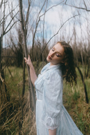 Girl holding a reed and leaning into camera