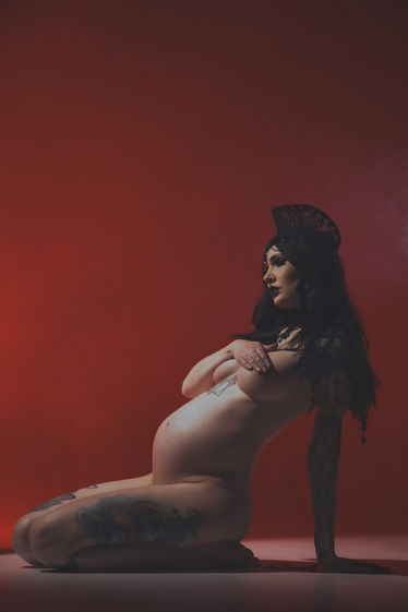 Alternative maternity portrait gothic on red photo studio cyclorama
