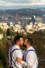 Gay wedding couple kiss in front of Portland skyline