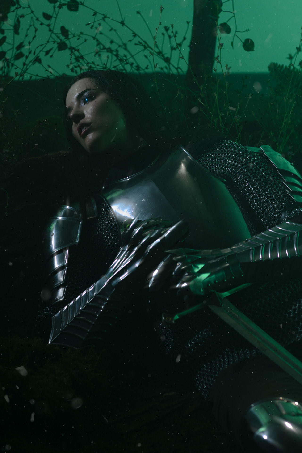 Teal studio forest with female fantasy warrioress in steel armor with sword