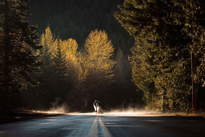 Bride and groom kiss in mist under glowing yellow trees leaving Cooper Spur elopement