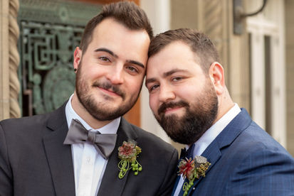 Gay couple pose for their wedding photographer in front of elegant door