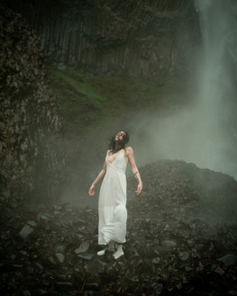 A beautiful model in white gets soaked by mist from PNW waterfall