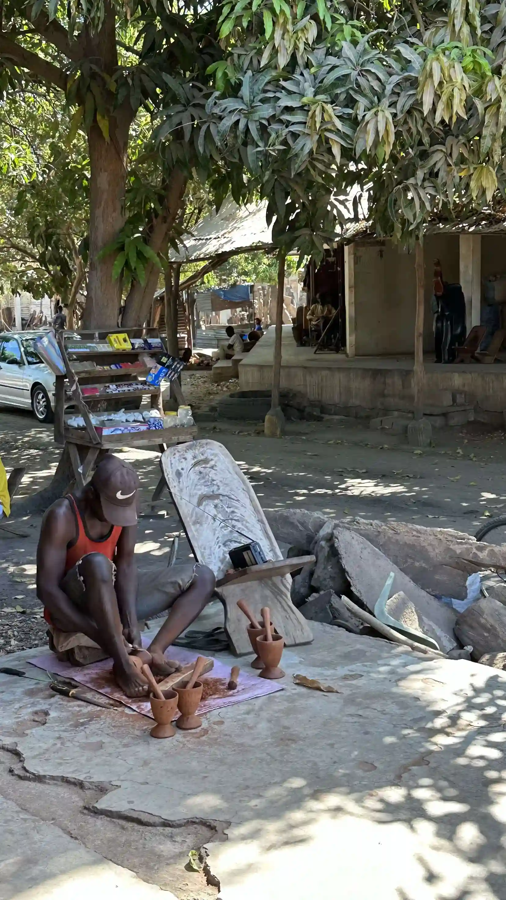 Artesano de madera trabajando en el mercado de artesanía de Brikama Gambia