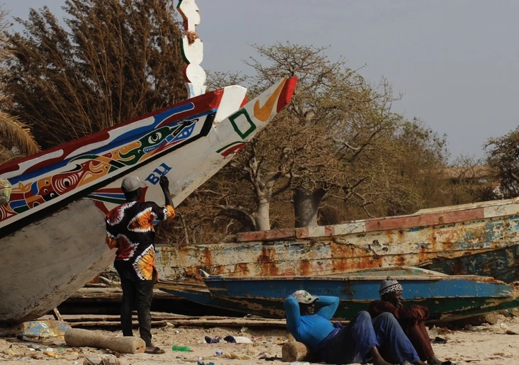 Pescador pintando cayuco Tanji puerto pesquero Gambia