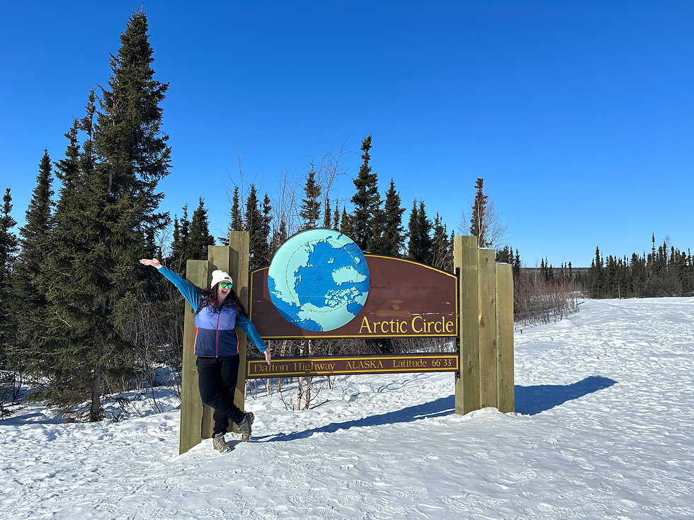 Woman at the Arctic Circle sign in Alaska.
