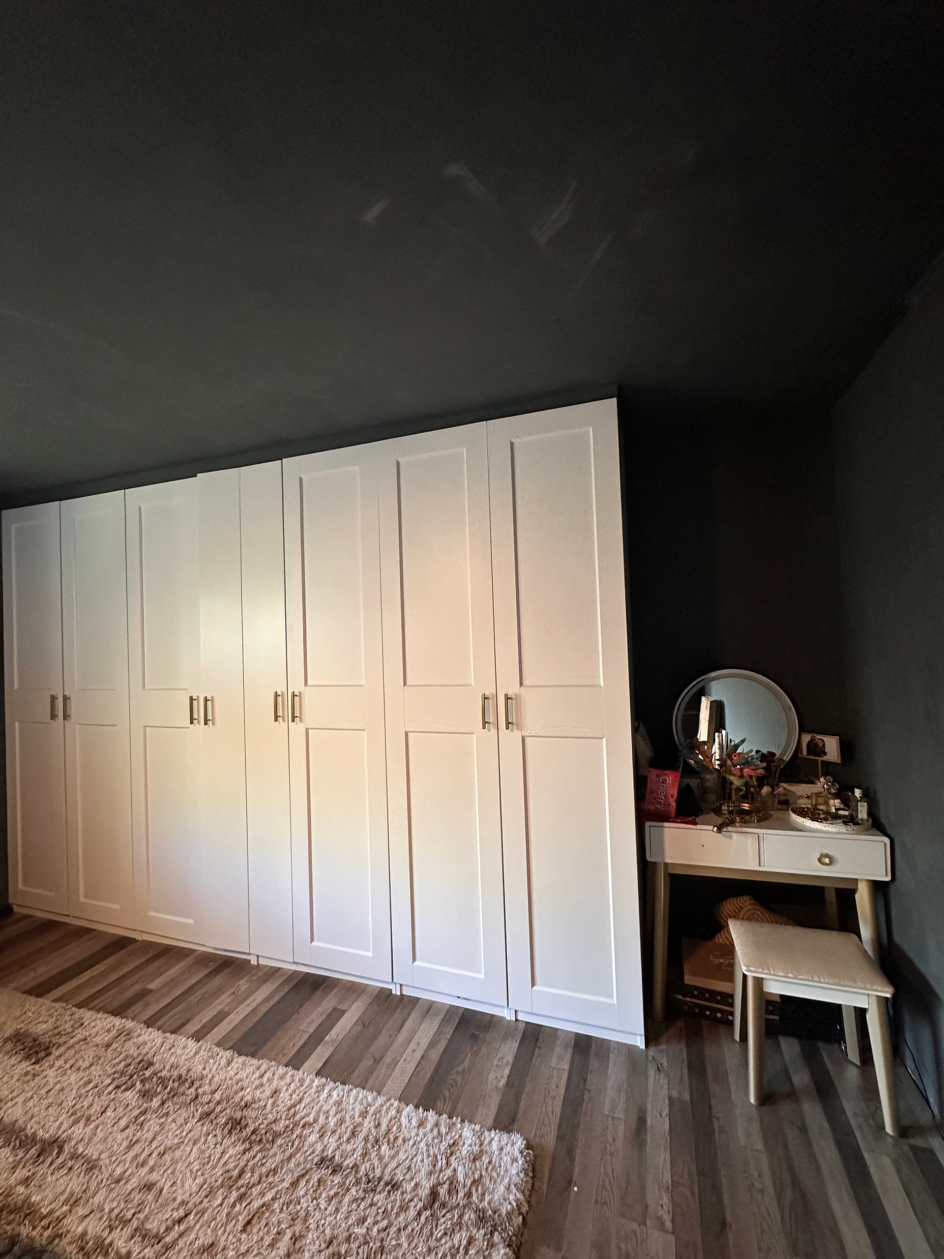 Moody black limewash bedroom with dark walls, vintage-inspired decor, and artistic, lived-in details