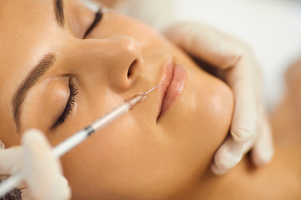Close-up of a woman receiving a lip injection, eyes closed, with gloved hands in a bright clinic setting.