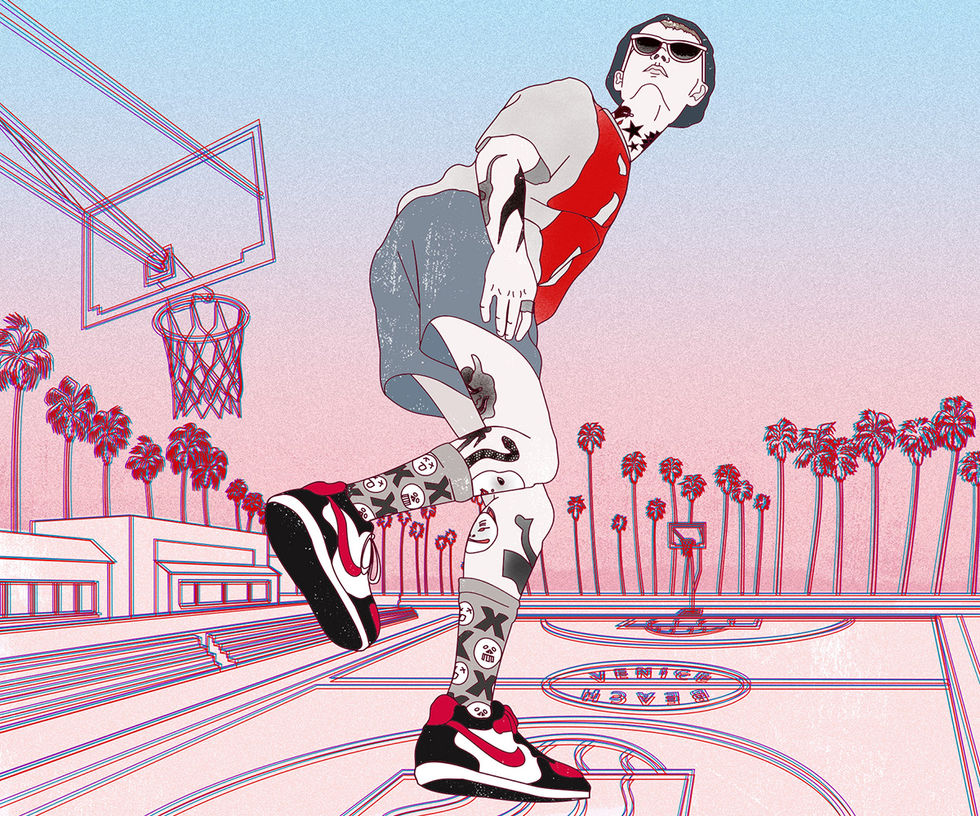 young tattooed guy walking across a basketball field in Venice Beach