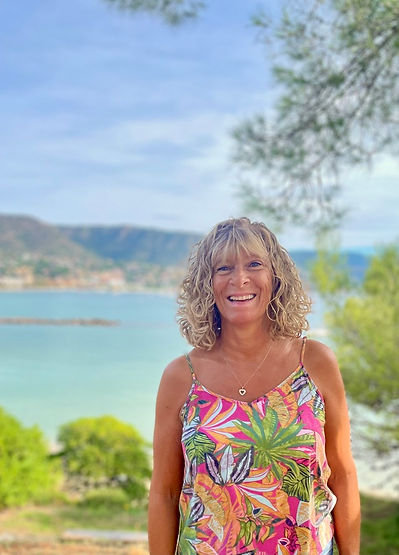 Femme qui sourit avec la mer en arrière plan.jpg