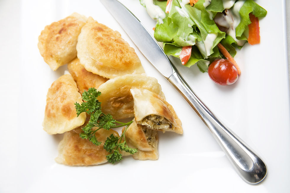 Pierogi on a plate with a knife and salad