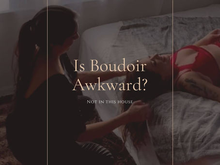 Boudoir photographer adjusting a client's hair and laughing together during a Wilmington, NC boudoir session