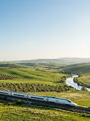 Electric Eco-Friendly AVE high-speed train traveling through green landscapes