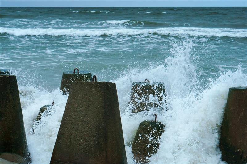 Waves crashing against flood barriers