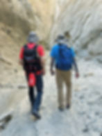 hikers walking through Skeleton Canyon towering rock walls