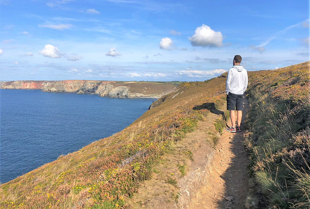 Walking the trail in St Agnes, England with views of the sea cliffs on the north coast of Cornwall