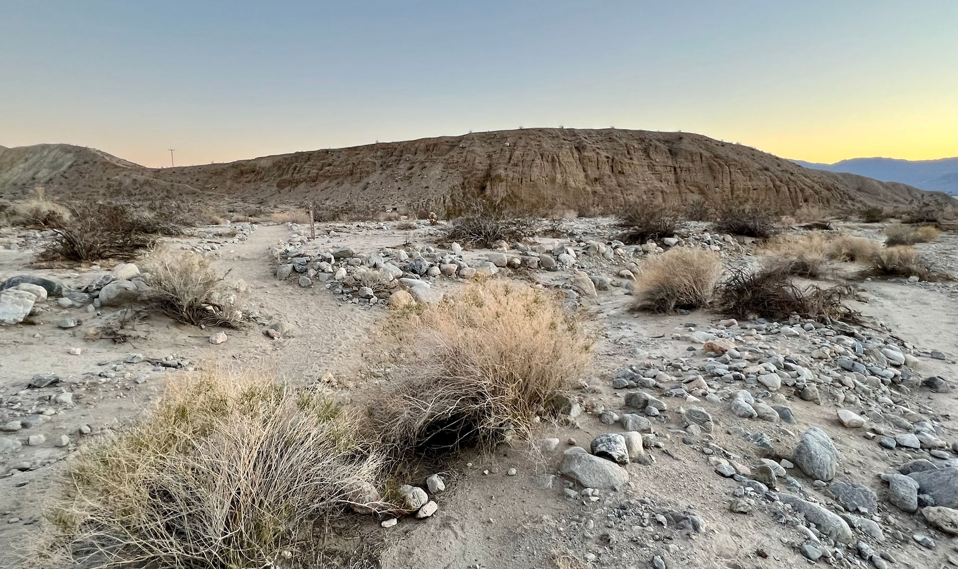 broad sandy wash with eroded Indio Hills at the start of the trail leading to Hidden Palms Oasis