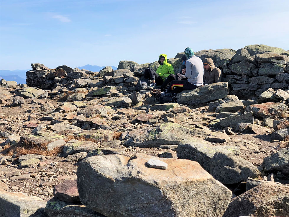 Taking shelter behind rock wall on the summit of Mt Moosilauke in NH. NH 4000 footer