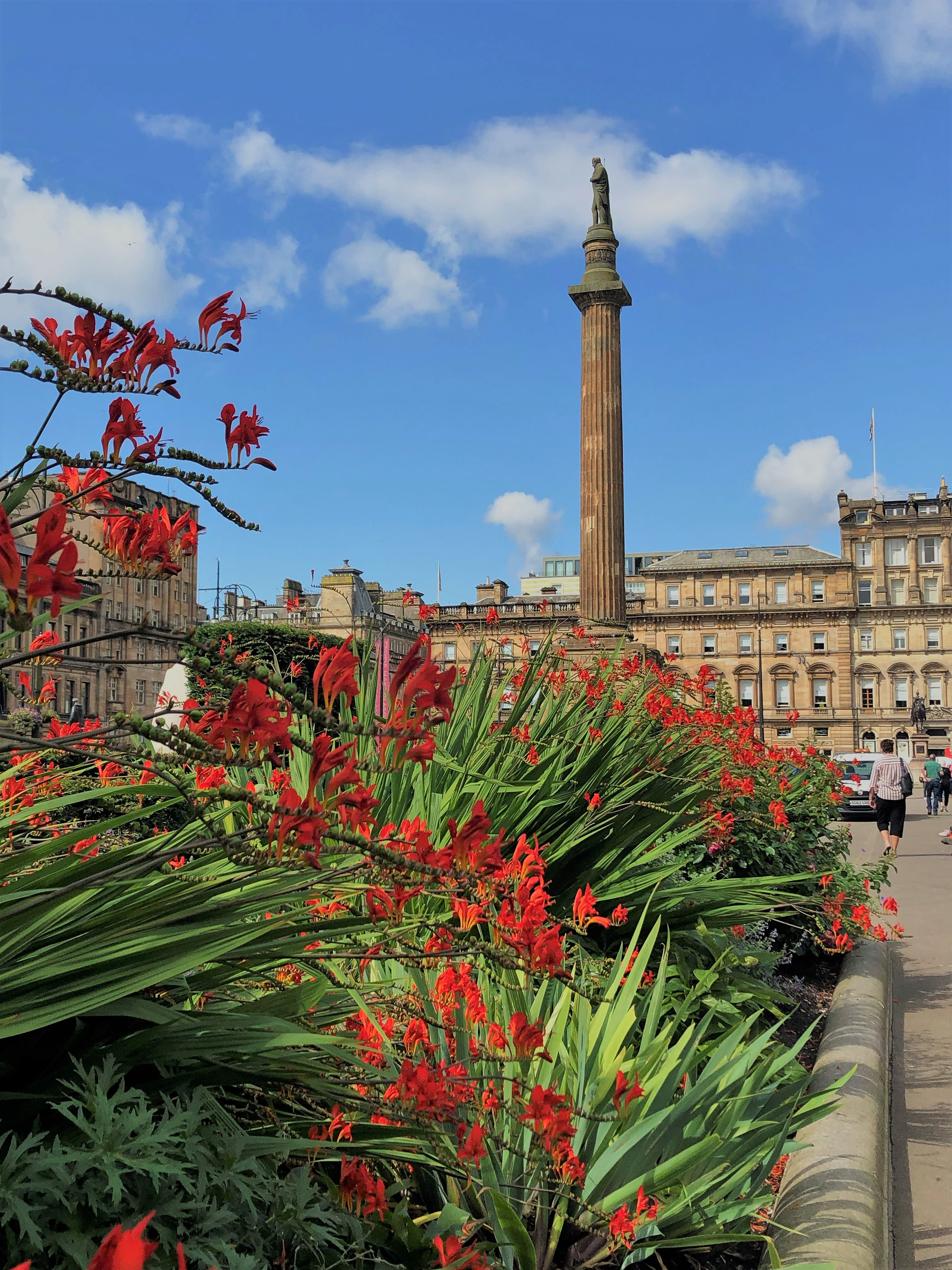 Statue is of Sir Walter Scott on the granite pillar in St George’s Square in center of Glasgow