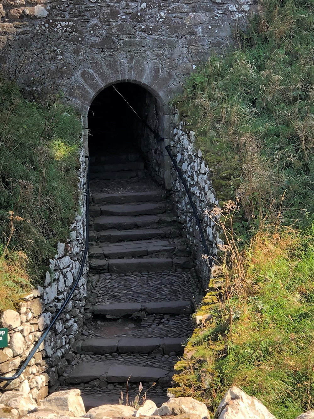 Dunnottar Castle’s entrance is through a gate, built into a wall which entirely blocks a cleft in the Dunnottar rock, and then continues underground