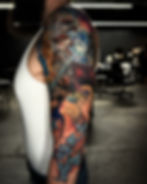 Full sleeve tattoo with colorful sci-fi and comic art.