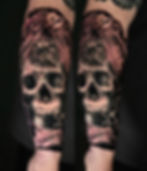 Detailed skull tattoo with intricate line work on forearm