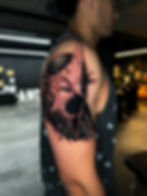 Detailed black and red biomechanical tattoo on upper arm