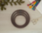 Set of three Matte Dark Brown seamless round embroidery hoops on wood background, styled with fabric, thread, and scissors