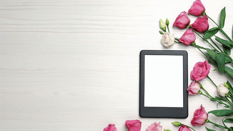 E-book reader with flowers on white wooden table, flat lay_edited_edited.jpg