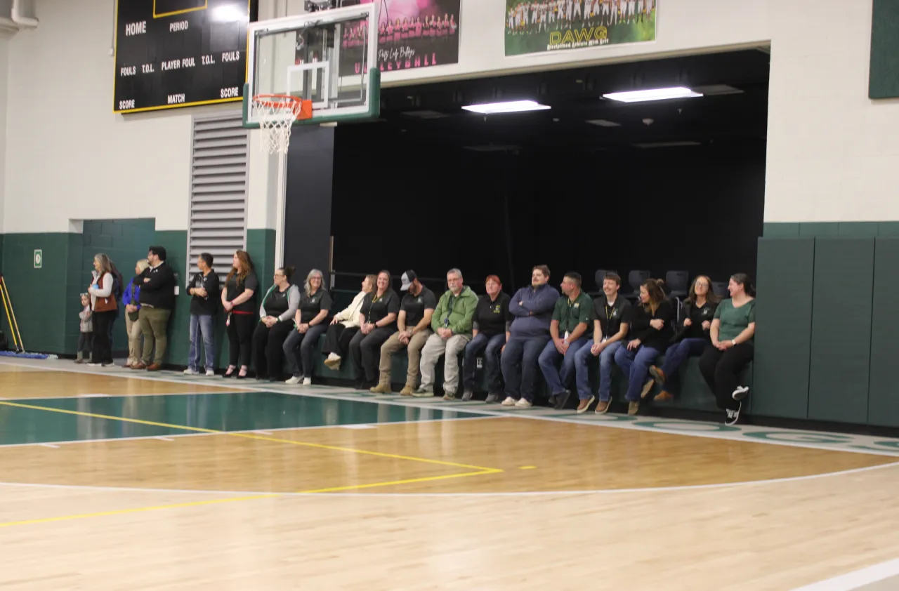 Peetz staff members, positioned in front of the school's new stage, listen to remarks during the gra