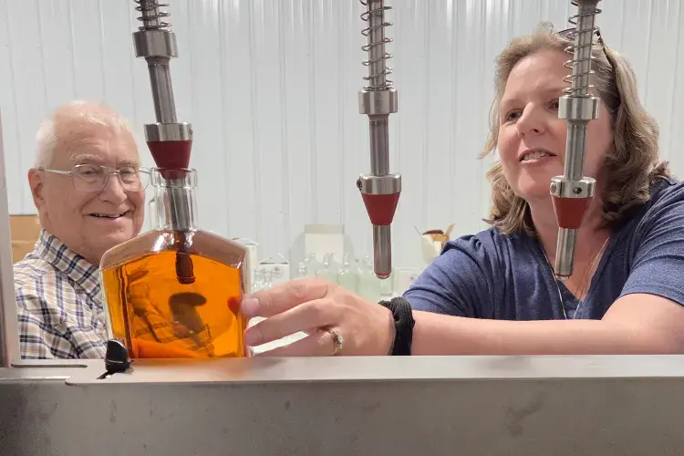 Tom Bindner and daughter Diane Williams bottle bourbon made from their century farm’s corn. Photo: Lisa Foust Prater