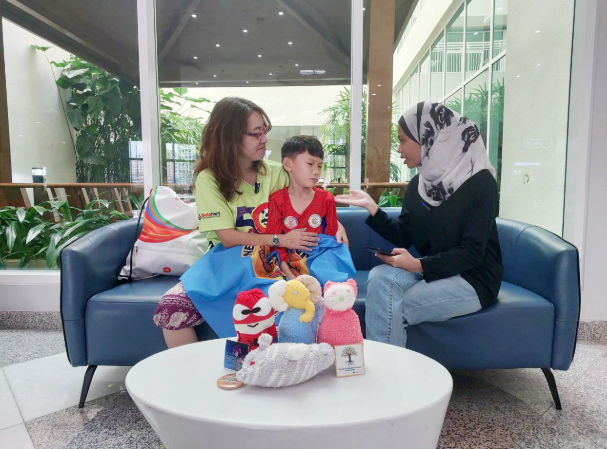 A Charisma Movement volunteer, Ainin, interviewing Patrick and his mother, Cordelia Lee, about their inspiring journey