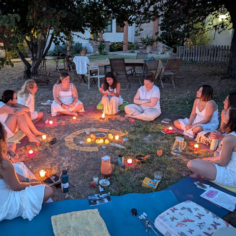 Círculo de mujeres con velas al aire libre en Alquimia Sagrada