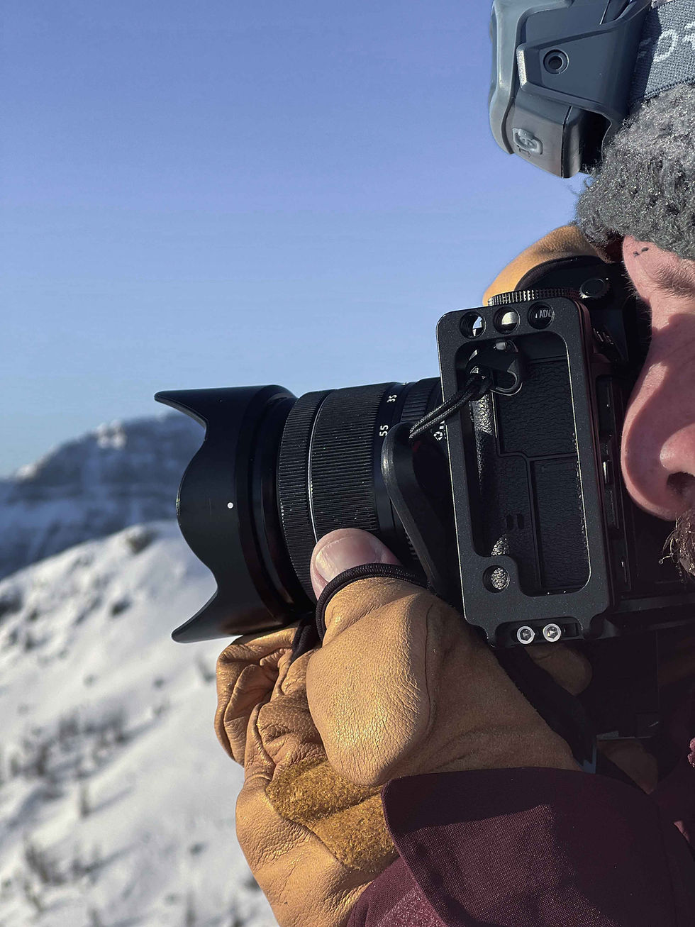 close-up van een fotograaf in een besneeuwd berglandschap