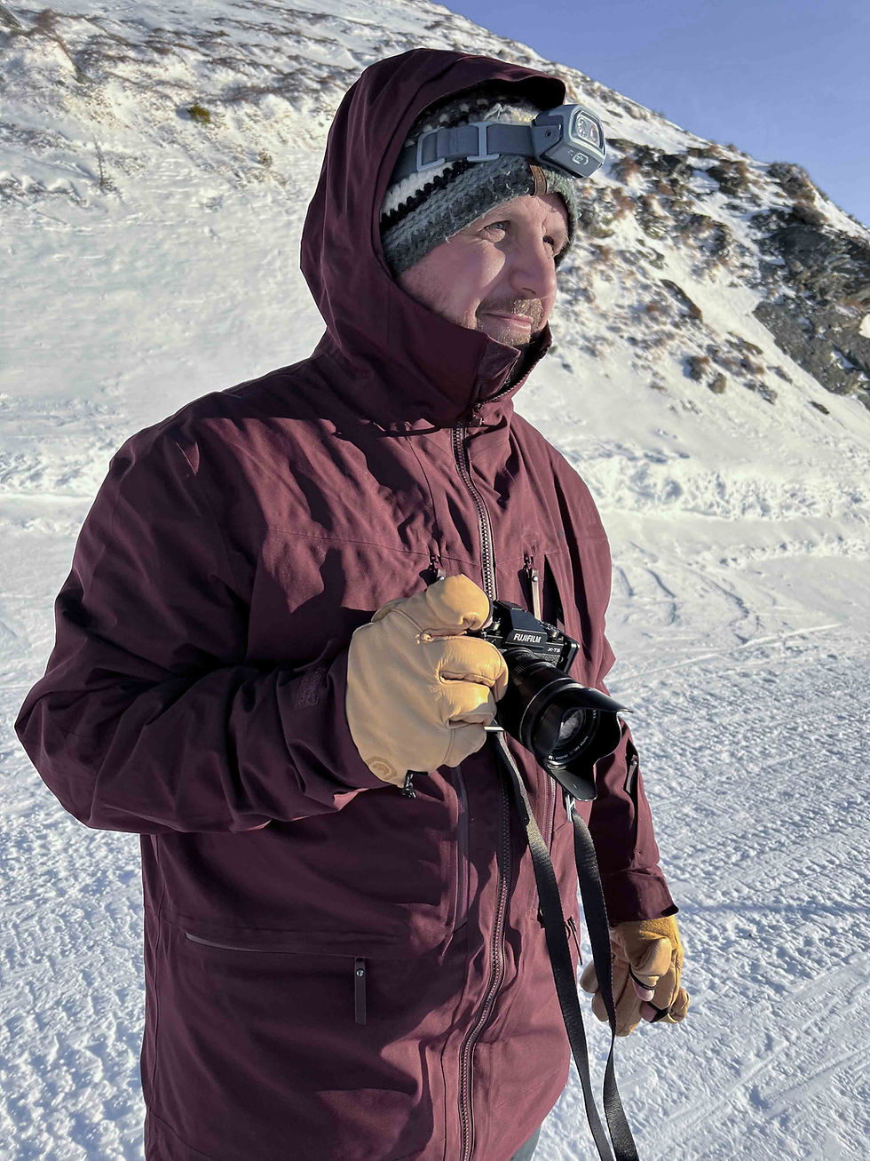 close-up van een fotograaf in een besneeuwd berglandschap