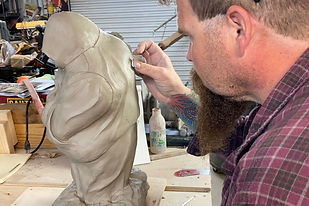 Artist working on a clay sculpture