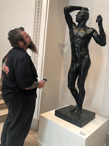 Artist looking at a Rodin Sculpture