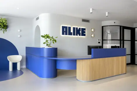 Modern healthcare reception area with a playful indigo blue and porters timber reception desk.  