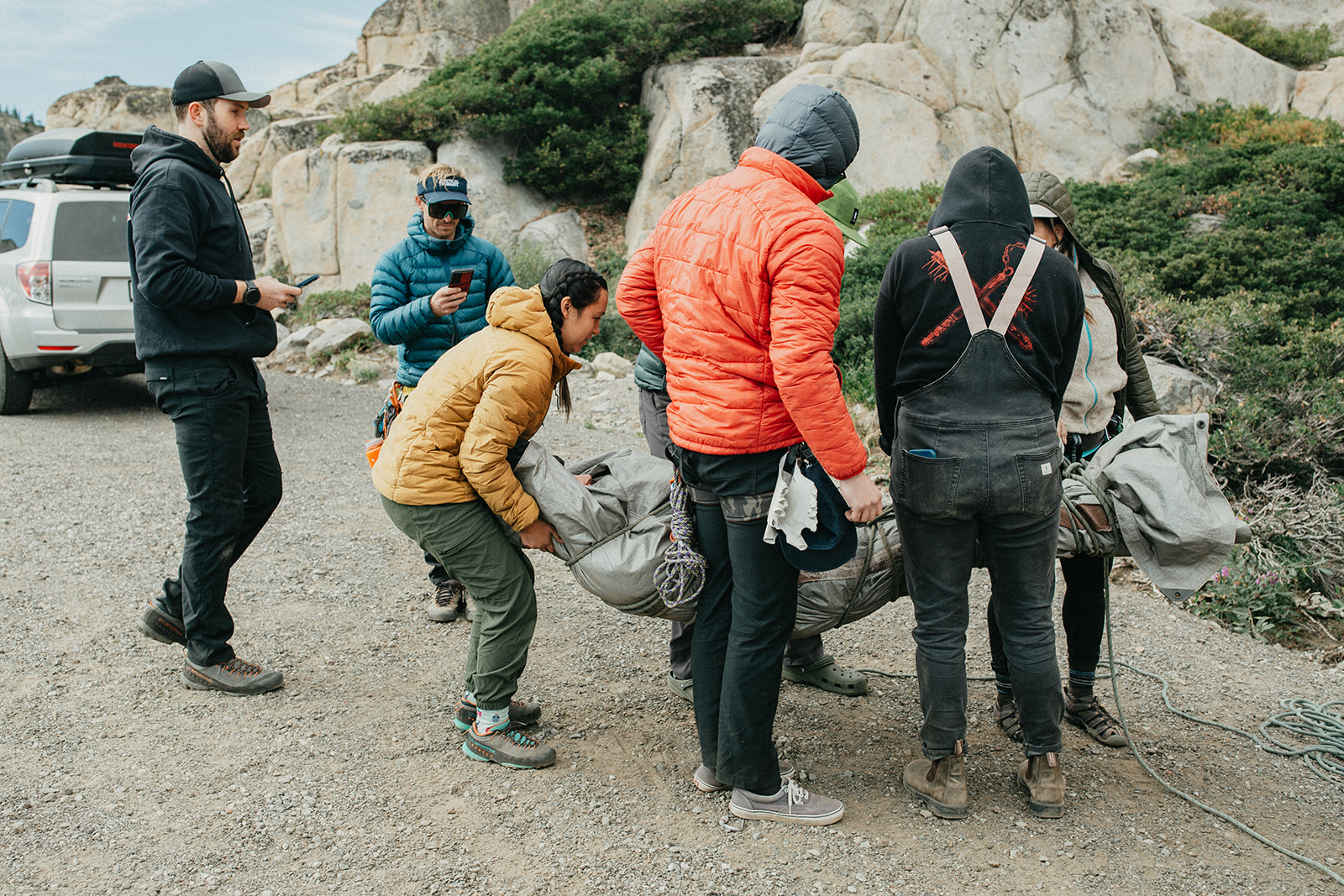 A group of course participants practices lifting and moving a simulated patient in an improvised litter