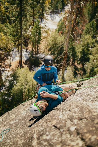 Student practicing wilderness medicine skills in a remote outdoor environment.