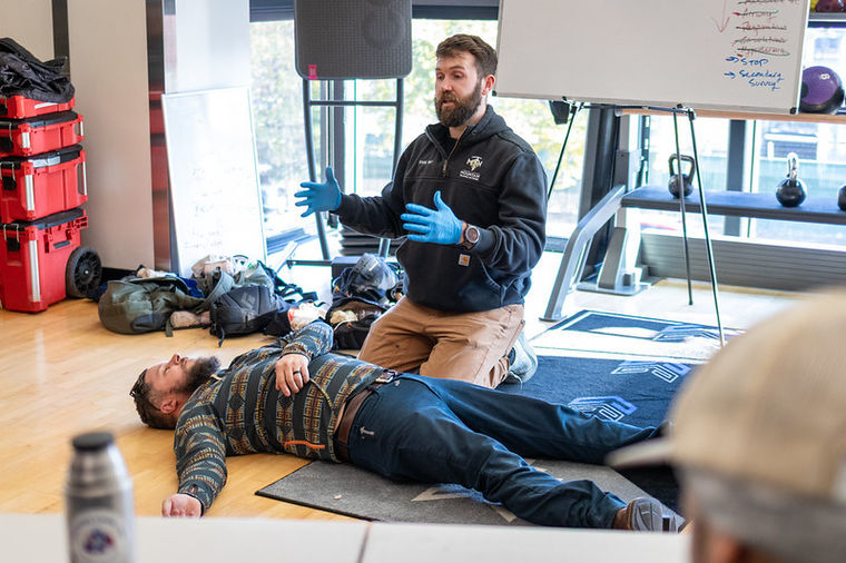 Instructor teaching patient assessment and treatment during wilderness medicine training.