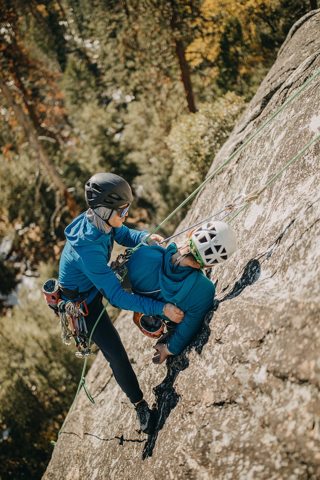 Erik and Ryan demonstrate assisted partner rescue while suspended on ropes against a granite wall
