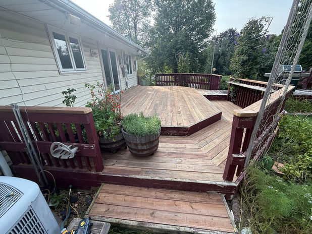 Wooden deck with railing near a house and trees. Decks deck builder near me.